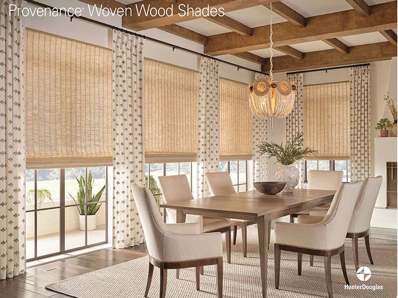 The image shows a modern interior space with a wooden floor, featuring a large window covered by vertical blinds and a dining table with chairs.